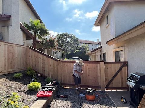 Working doing final touches on a fence installation in San Diego