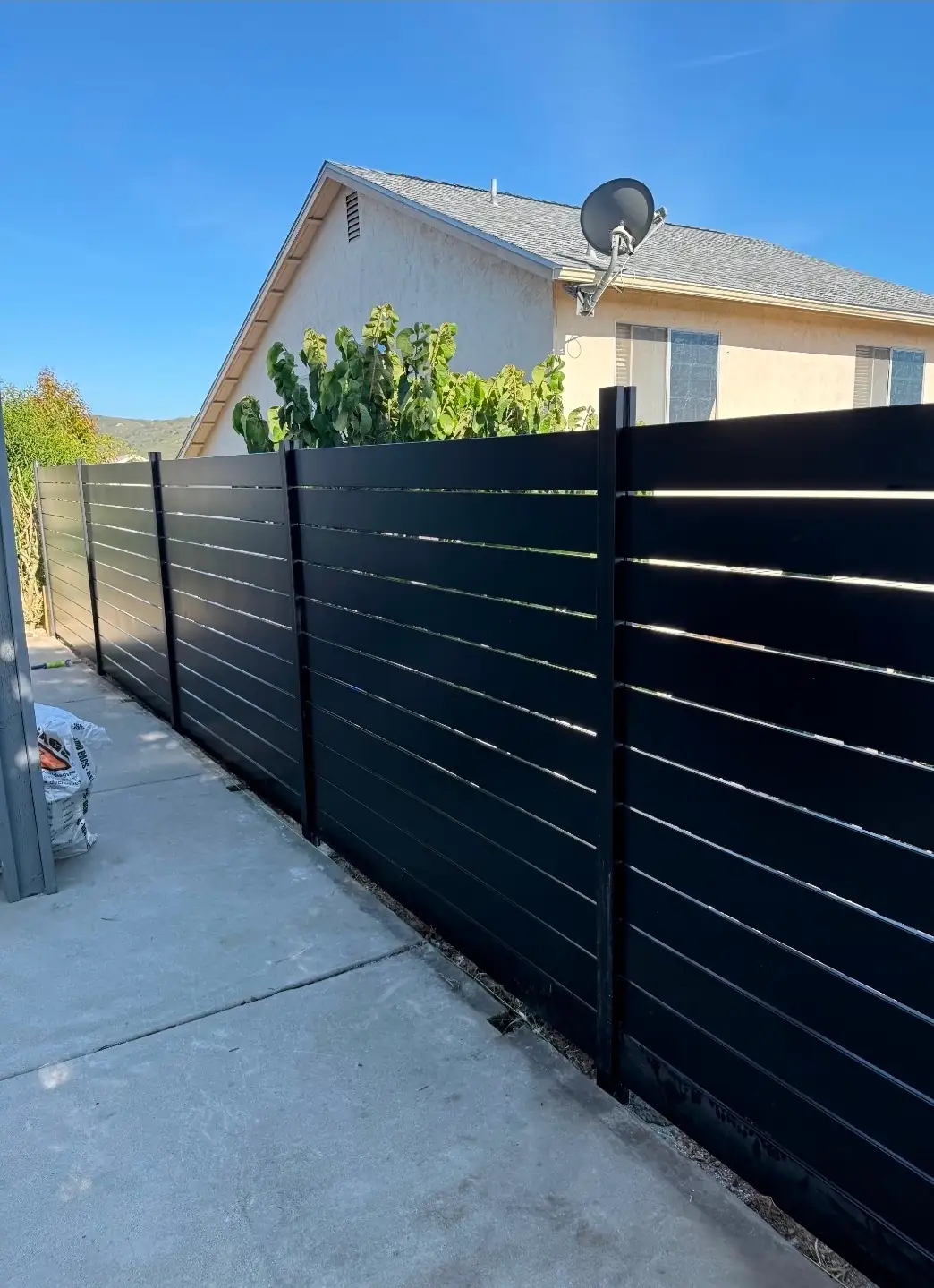 Angled view of black horizontal aluminum fence panels for backyard privacy in San Diego