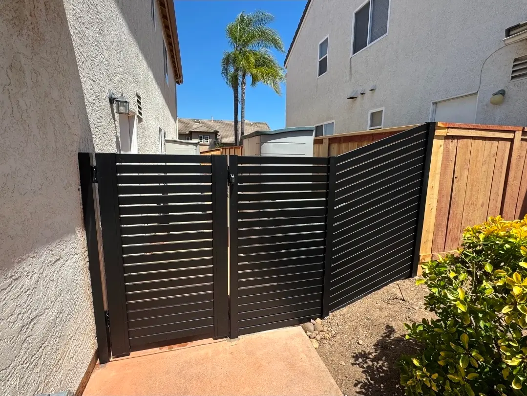 Custom black aluminum privacy gate and matching horizontal fence installed at a San Diego residence